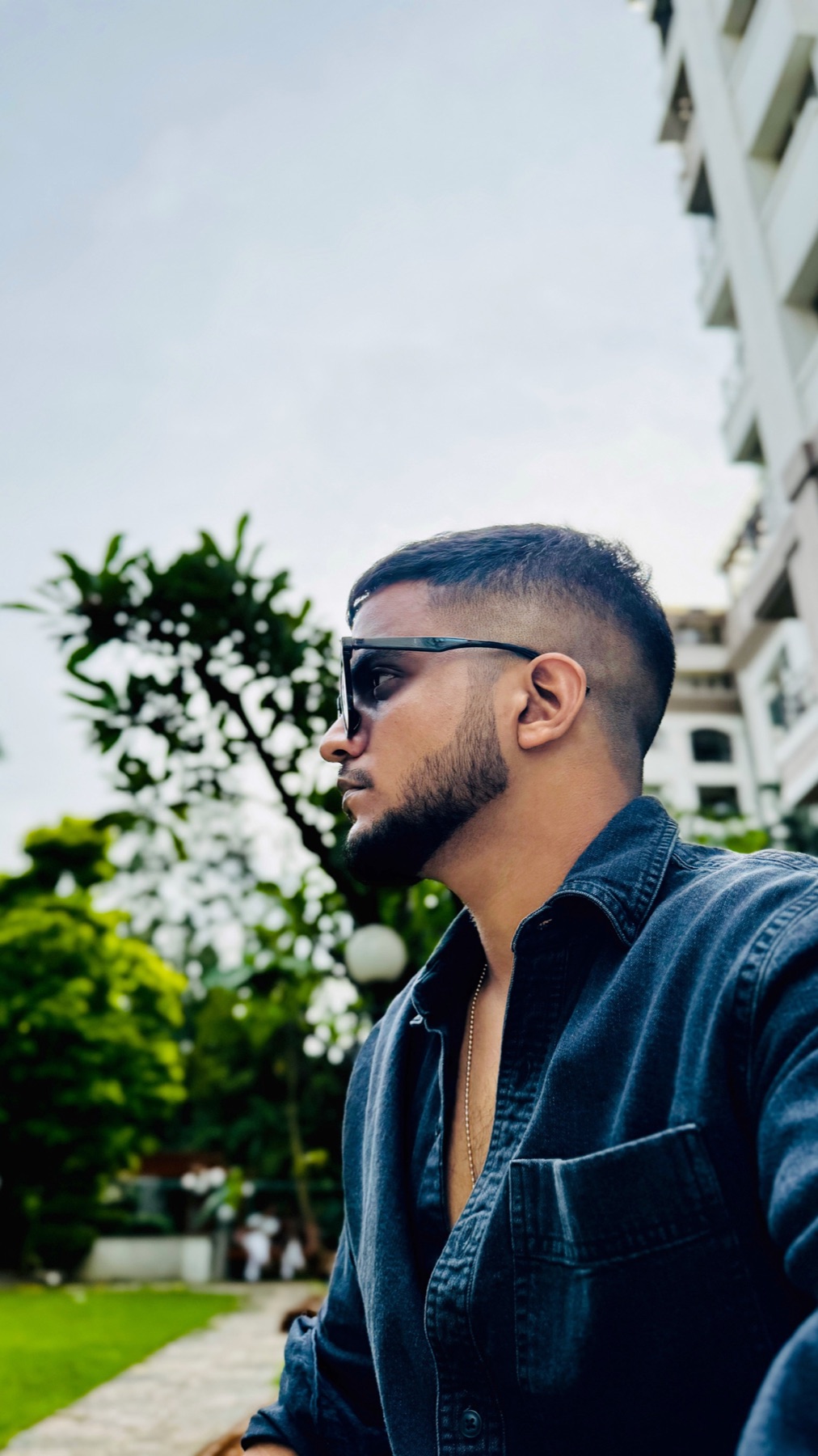 AYSH outdoors in a blue shirt and sunglasses