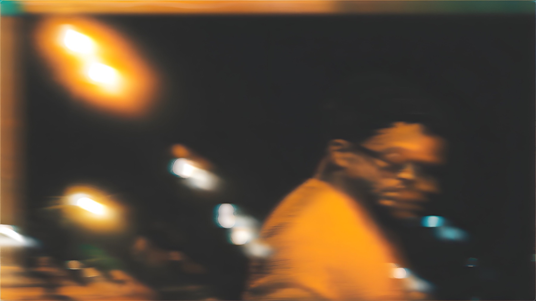 Cinematic motion portrait of AYSH under orange light at night